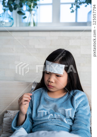 A girl with a cold eating rice 125057794