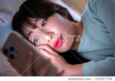A woman who watches the smartphone after late at night A woman who watches the smartphone after late at night 125057798