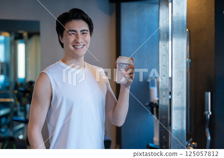 Men drinking protein in the gym 125057812