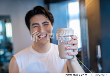 Men drinking protein in the gym 125057813