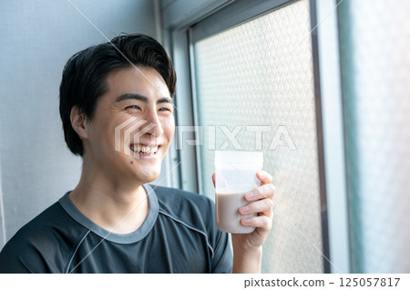 Men drinking protein in the gym 125057817