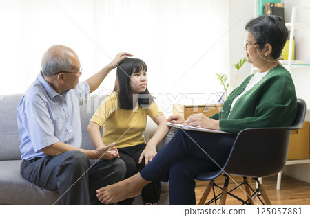 Parents telling the psychologist about family or child problems. Depressed girl and her parent or grandpa having session with psychiatrist in clinic. Parents telling the psychologist about family or child problems. Depressed girl and her parent or grandpa having session with psychiatrist in clinic. 125057881