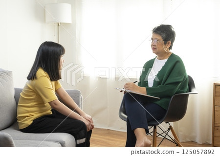 Depressed asian girl having consultation with psychologist at clinic. Depressed asian girl having consultation with psychologist at clinic. 125057892