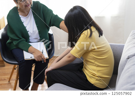 Depressed asian girl having consultation with psychologist at clinic. 125057902
