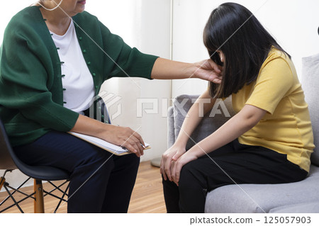 Depressed asian girl having consultation with psychologist at clinic. Depressed asian girl having consultation with psychologist at clinic. 125057903
