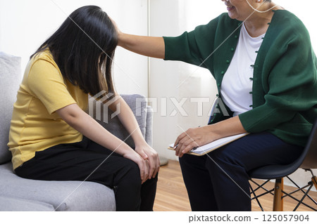 Depressed asian girl having consultation with psychologist at clinic. Depressed asian girl having consultation with psychologist at clinic. 125057904