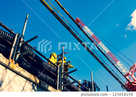 Crane and electric wire protection cover at a construction site a-3 Emphasis on warm and cool colors 125058159