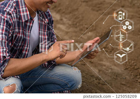 Modern farmer using digital tablet to access smart farming data 125058209