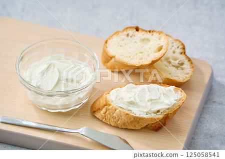 Cream cheese spread on French bread 125058541