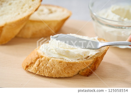 Cream cheese spread on French bread 125058554
