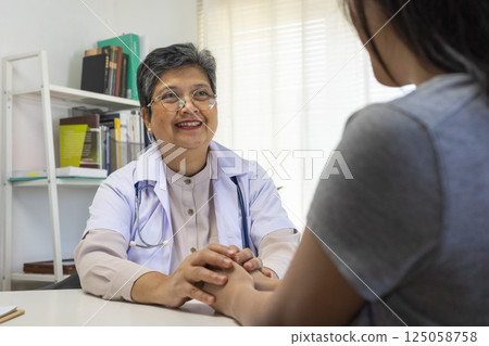 Patient writing personal info while listen to the senior doctor. Patient writing personal info while listen to the senior doctor. 125058758