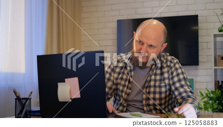 Bald man answering calls to provide vital support, as support fosters trust and support accelerates positive client relations, ensuring smooth communication in real time. Remote work of man Bald man answering calls to provide vital support, as support fosters trust and support accelerates positive client relations, ensuring smooth communication in real time. Remote work of man 125058883