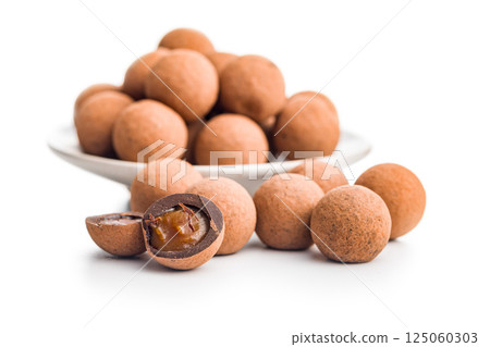 Chocolate truffles with cocoa powder and caramel filling isolated on white background. Chocolate truffles with cocoa powder and caramel filling isolated on white background. 125060303