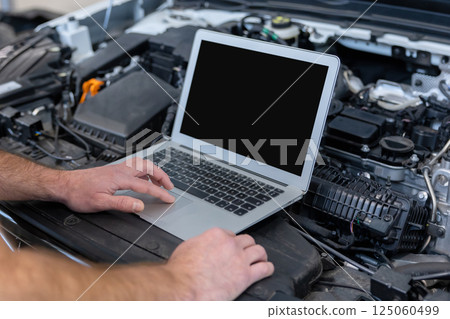 Mechanic man mechanic using laptop computer checking car Mechanic man mechanic using laptop computer checking car 125060499