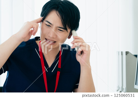 一位面帶憂慮的醫生在用智慧型手機說話 125060531