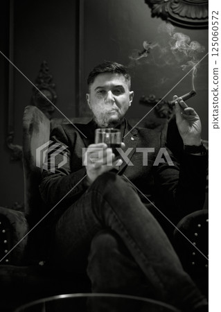 smoking senior businessman wearing dark suit smoking senior businessman wearing dark suit 125060572