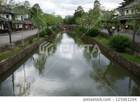 Okayama Prefecture, Kurashiki - Enjoy a stroll through the retro town while admiring the willow trees and clouds reflected on the river surface Okayama Prefecture, Kurashiki - Enjoy a stroll through the retro town while admiring the willow trees and clouds reflected on the river surface 125061284