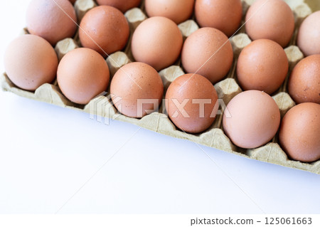 Fresh chicken brown eggs in a tray on a white background Fresh chicken brown eggs in a tray on a white background 125061663