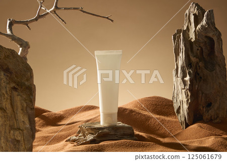 Cosmetic tube mockup placed on a wooden board desert landscape. The rocky mountain is uneven, many places are eroded and mottled. The winding wooden branch has sharp thorns and bare branches. Cosmetic tube mockup placed on a wooden board desert landscape. The rocky mountain is uneven, many places are eroded and mottled. The winding wooden branch has sharp thorns and bare branches. 125061679