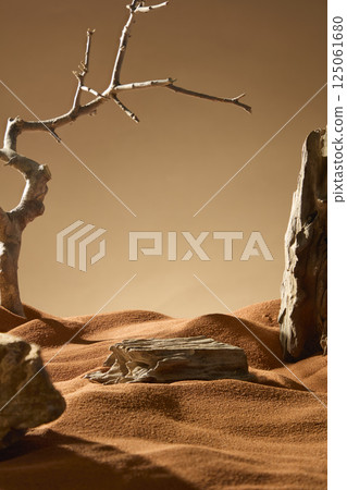 Vertical photo of a wooden platform placed on brown sand in the desert. The sand is dried by the sun. Dead tree twisted with thorny branches. The logs are placed around, creating a vast desert scene. Vertical photo of a wooden platform placed on brown sand in the desert. The sand is dried by the sun. Dead tree twisted with thorny branches. The logs are placed around, creating a vast desert scene. 125061680