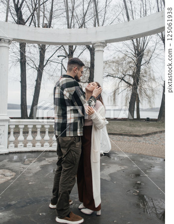 Young couple in stylish clothes on a walk. Romantic date outdoors. Walk, kisses and hugs 125061938