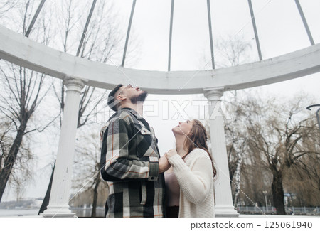 Young couple in stylish clothes on a walk. Romantic date outdoors. Walk, kisses and hugs 125061940