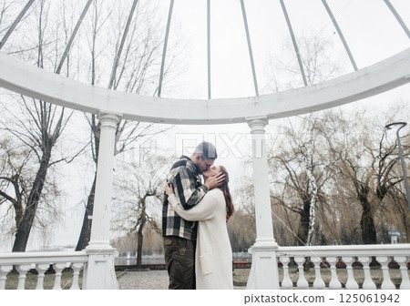 Young couple in stylish clothes on a walk. Romantic date outdoors. Walk, kisses and hugs 125061942