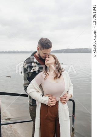Young couple in stylish clothes on a walk. Romantic date outdoors. Walk, kisses and hugs Young couple in stylish clothes on a walk. Romantic date outdoors. Walk, kisses and hugs 125061943