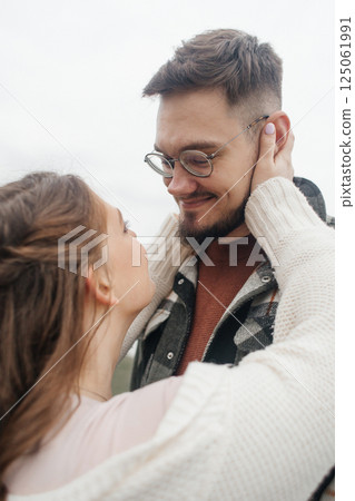 Young couple in stylish clothes on a walk. Romantic date outdoors. Walk, kisses and hugs 125061991