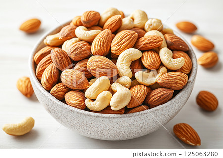 Bowl of mixed nuts on a white background. Almonds, walnuts and cashews, rich in magnesium and B vitamins. Healthy snacks. 125063280
