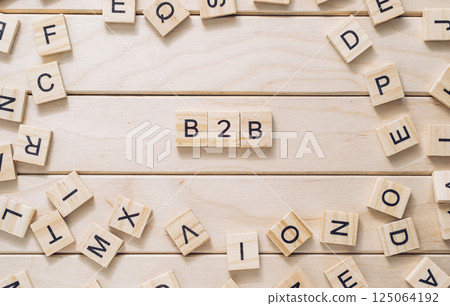 Wooden board with a bunch of wooden letters scattered around it 125064192