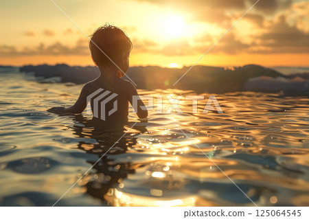 Child is in the water at sunset 125064545
