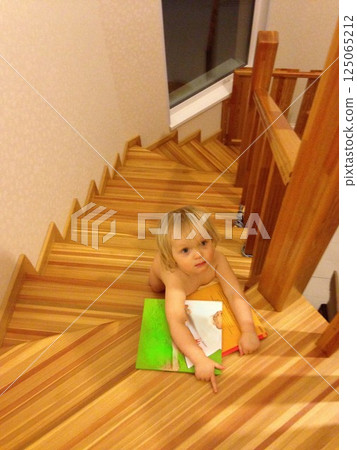 Curious Child on Stairs with Books Exploring 125065212