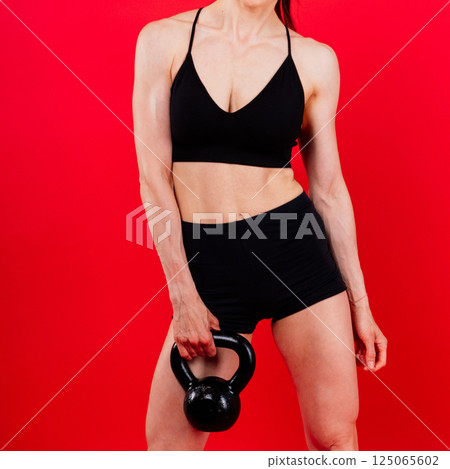 Fitness woman doing crossfit exercising with kettle bell with muscular fit and slim body. 125065602