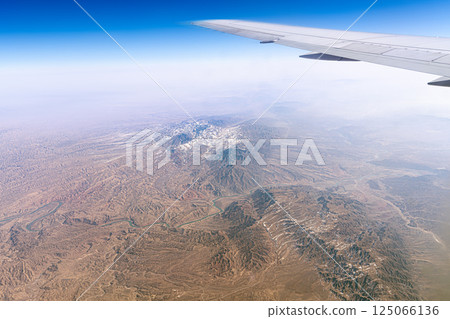 Mountain range mountains in the Tibetan Plateau in China View from above from under the wing of an airplane. Xinjiang Uygur geology 125066136