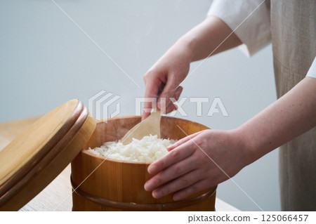 A woman serving rice from a rice cooker A woman serving rice from a rice cooker 125066457