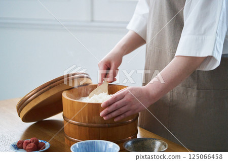 一位女士正在用電鍋盛飯 125066458