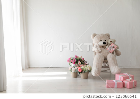 Polar bear toy and flower and gifts in the interior of a white room 125066541