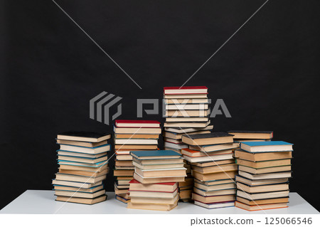 Stacks of old books for studying in the library on a black background of the university 125066546