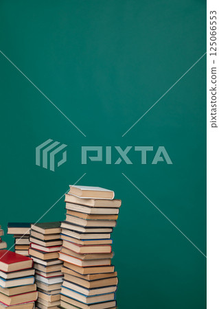 Stacks of old educational books for study in the library on a green background at the university 125066553
