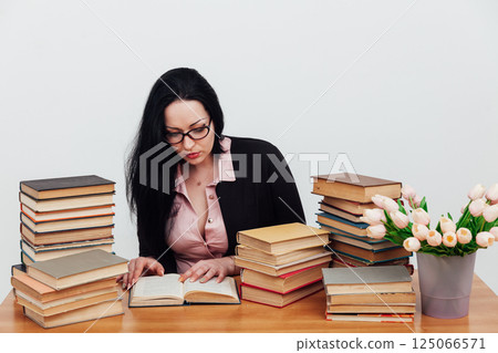 business woman teacher and stacks of educational books on table business woman teacher and stacks of educational books on table 125066571