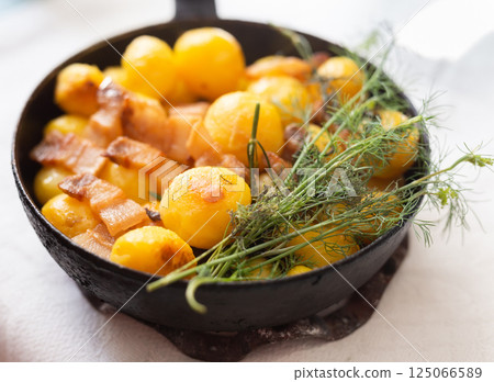 Young potatoes with pork belly fried in frying pan Young potatoes with pork belly fried in frying pan 125066589