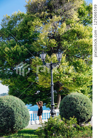 woman in black summer dress posing and walking around town 125066599
