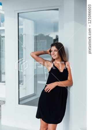 woman in black summer dress posing and walking around town woman in black summer dress posing and walking around town 125066603