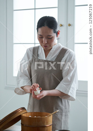 A woman holding a rice ball 125067159