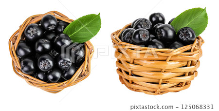 Chokeberry with leaf in a wicker basket isolated on white background. Black aronia. Top view. Flat lay Chokeberry with leaf in a wicker basket isolated on white background. Black aronia. Top view. Flat lay 125068331