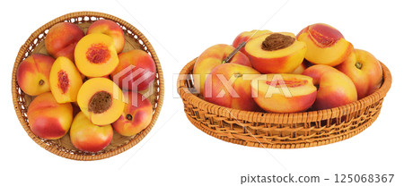 Ripe nectarine fruit with half in a wicker basket isolated on white background. Top view. Flat lay Ripe nectarine fruit with half in a wicker basket isolated on white background. Top view. Flat lay 125068367