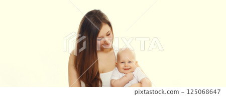 Happy smiling young mother playing with cute baby sitting together on the floor on white background Happy smiling young mother playing with cute baby sitting together on the floor on white background 125068647