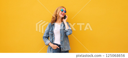 Happy cheerful young woman laughs calling on phone, girl talking on smartphone in denim clothing 125068656