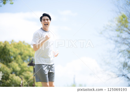 A man running or jogging under a blue sky A man running or jogging under a blue sky 125069193